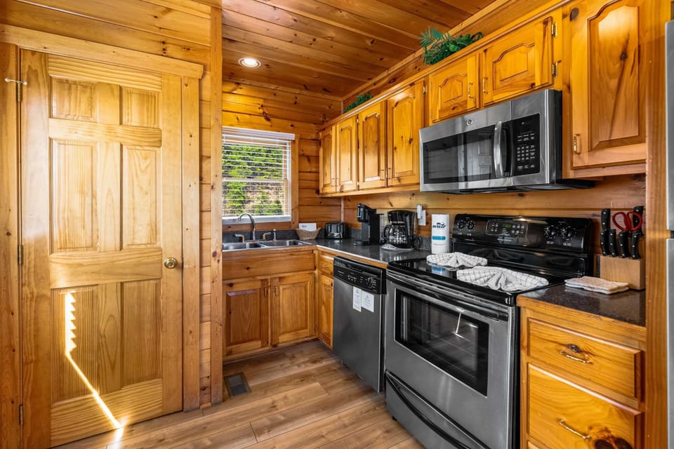 Kitchen, whip up culinary delights in this charming wooden kitchen with modern appliances!