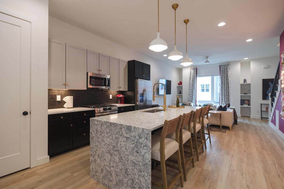 Modern kitchen with a large island and open living area.