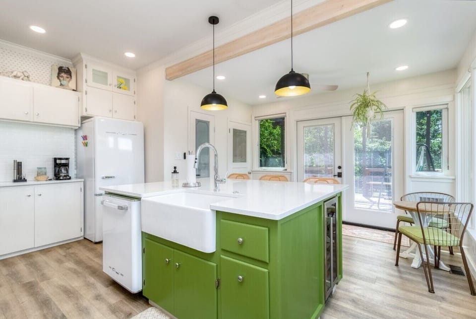 Bright, fully equipped kitchen with island seating and backyard access.