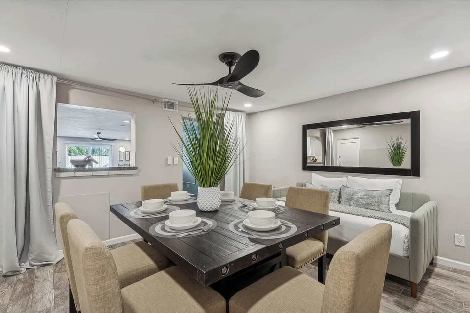 Dining area featuring a rustic dark wood table with seating for six. A cozy daybed adds extra comfort, allowing the room to function as a flexible space for extra guests.