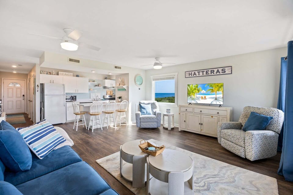 Large windows fill the space with natural light and showcase the home's coastal setting.