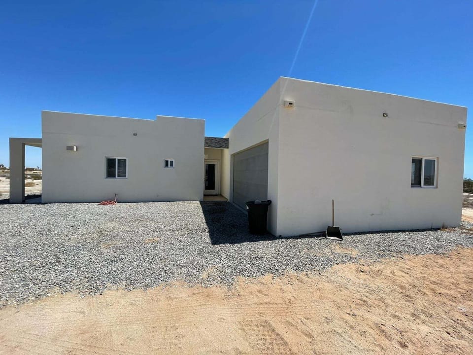 An exterior perspective captured from the left side of the property, showcasing the architectural depth of the building complex, structural lines, and surrounding landscape integration.