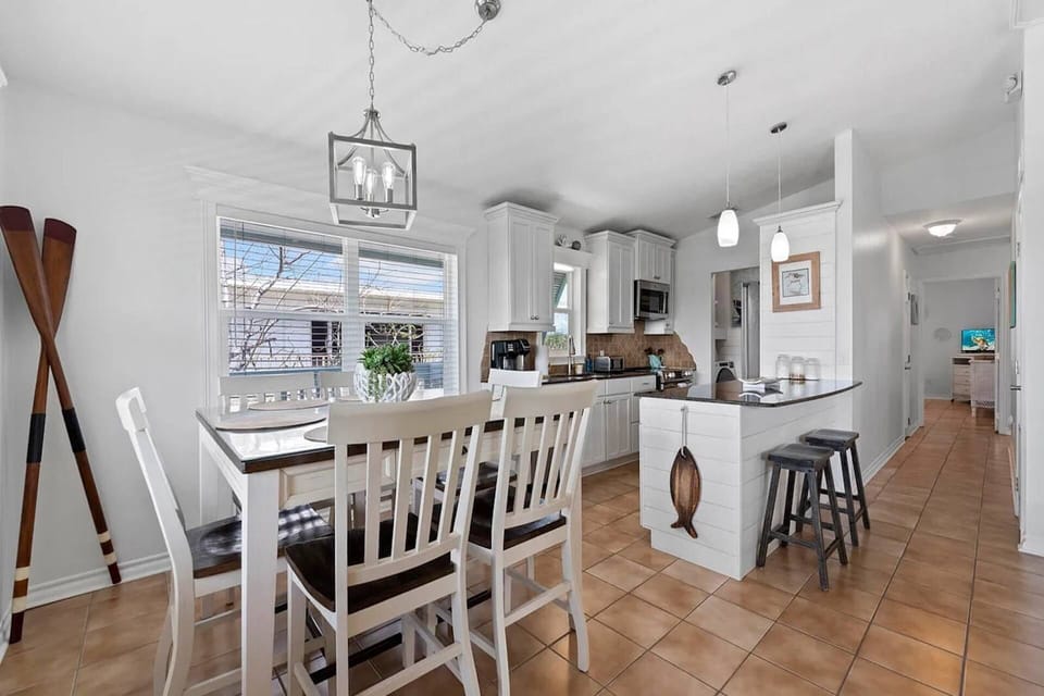 Bright dining area & fully equipped kitchen with island seating, creating the perfect space for meals, conversation, & planning your Keys adventures.