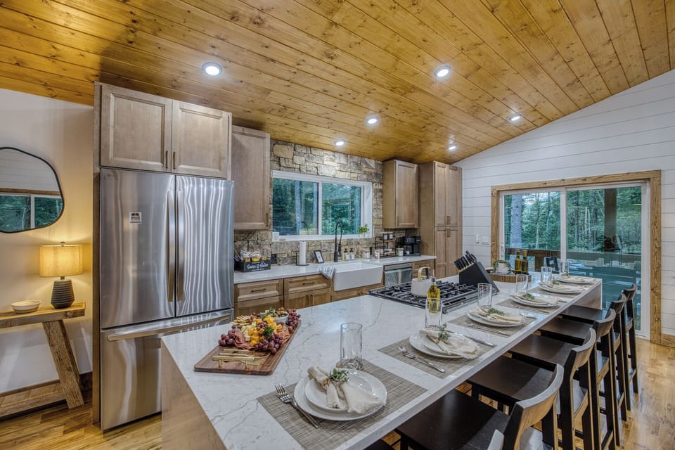 Spacious gourmet kitchen with island seating and serene forest views