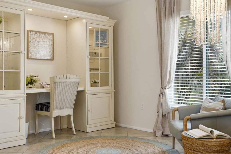 The Out of Office sign on the shelf is aspirational. The glass-cabinet desk is where you'll actually get things done when you have to.
