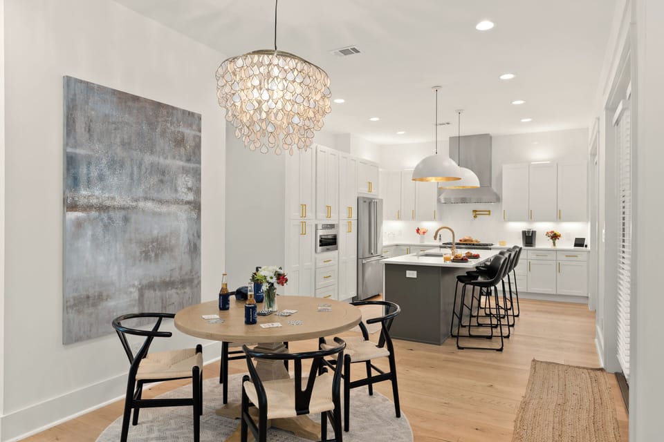 Beautifully framed view from the dining table transitioning into the high-end, modern chef's kitchen.