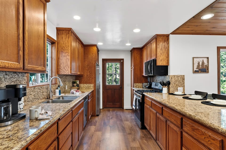 Full kitchen with granite counters, ample cabinetry, and easy cabin-style charm.