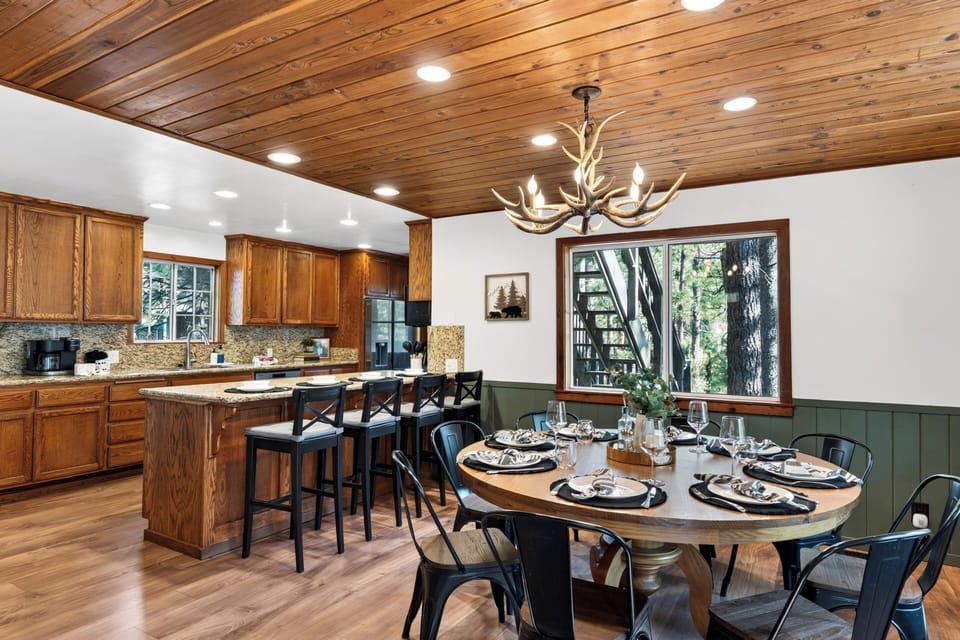 Forest-view dining area with warm wood ceilings and cabin-inspired style.