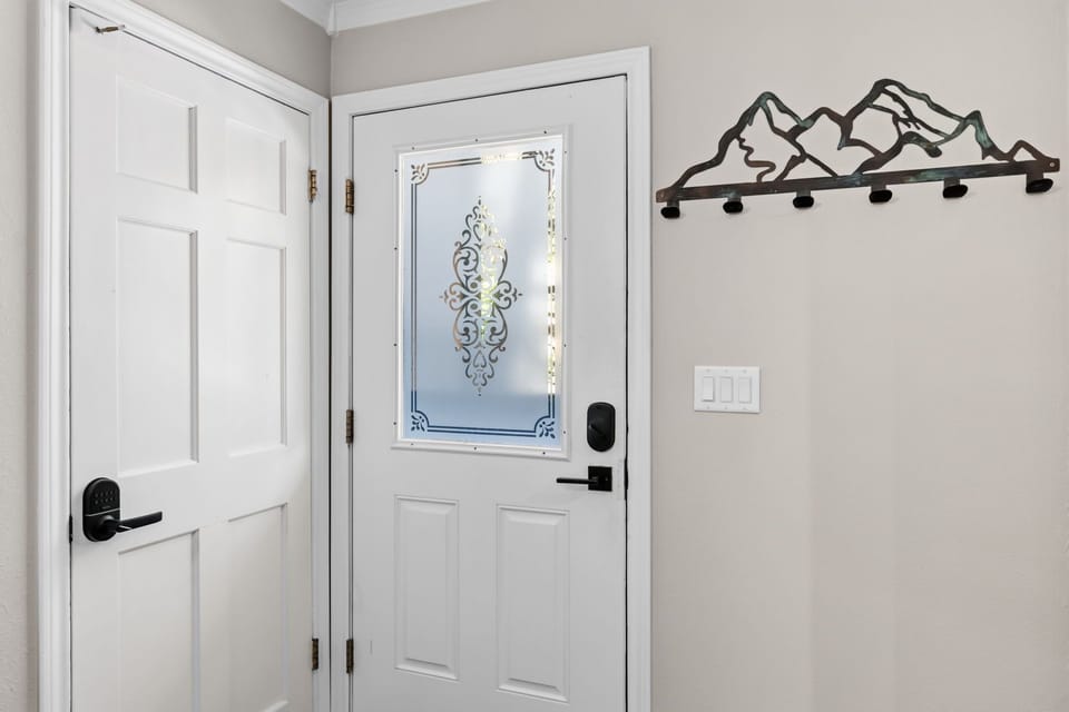 The elegant frosted glass entry welcomes you to your mountain getaway, with decorative hooks and a closet nearby to store your gear after a day exploring.