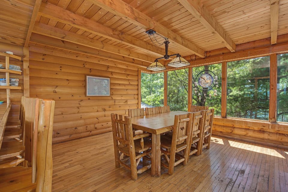 Step into your rustic dining retreat where sunlight pours through floor-to-ceiling windows, revealing serene forest views while you gather around the handcrafted log table for meals and memories.