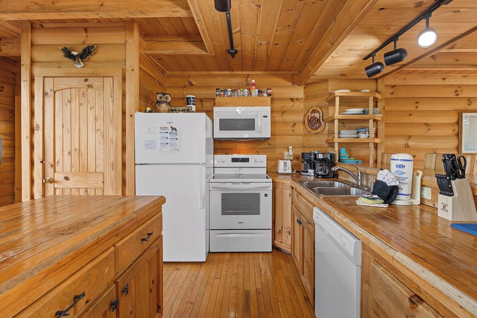Your rustic cabin kitchen features warm wood finishes, modern appliances, and all the essentials for comfortable meal prep during your mountain getaway.