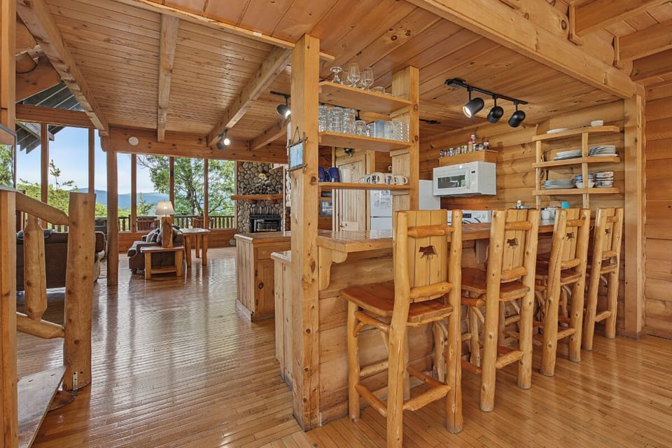 Gather around the handcrafted wooden bar in your mountain retreat, where rustic charm meets modern convenience. Open shelving, natural light, and scenic views create the perfect setting for your mornings and evenings together.