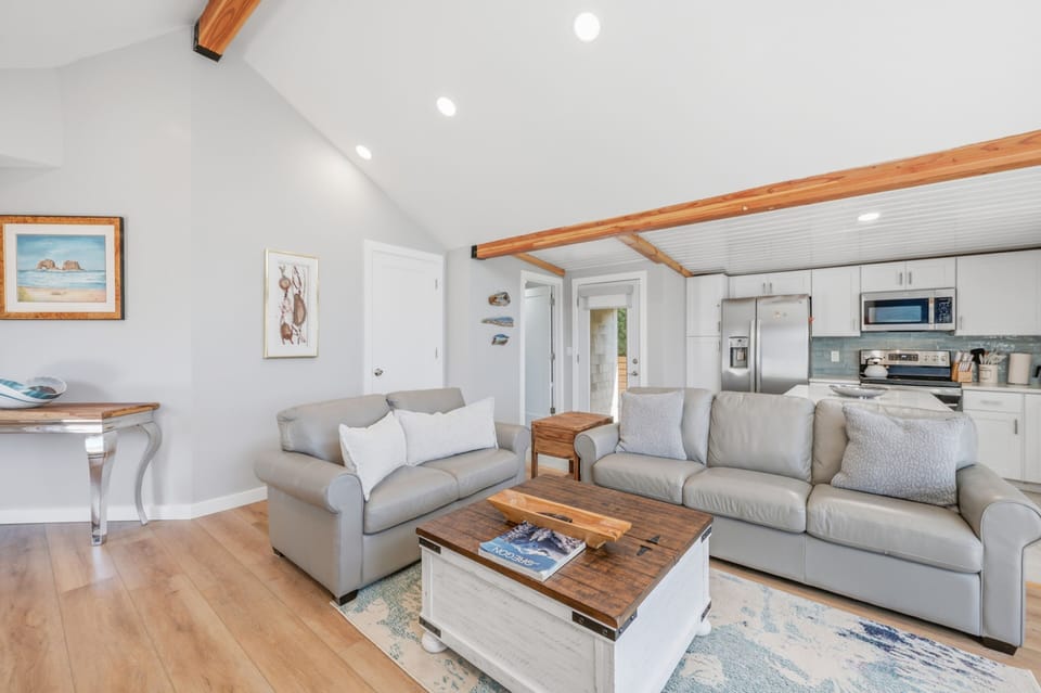 You'll love the vaulted ceilings and warm wood beams that frame this bright, airy space—perfect for unwinding after a day at the beach.