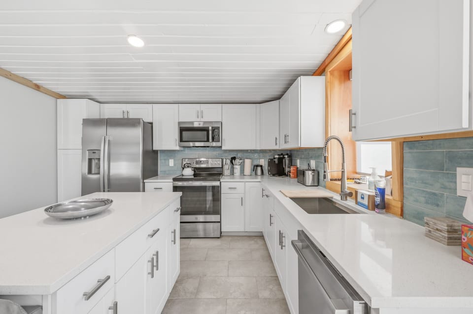 You'll have everything you need in this bright, spotless kitchen: modern stainless appliances, tons of counter space, and a window bringing in warm natural light as you prep meals.