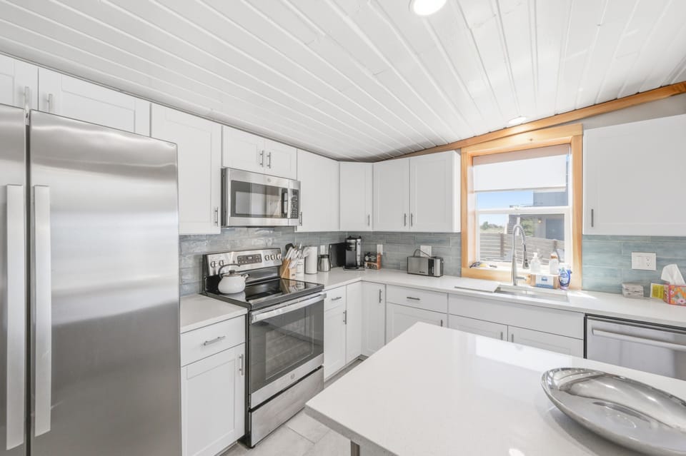 Your bright, modern kitchen features stainless steel appliances and crisp white cabinetry, with ample counter space for preparing meals and gathering with loved ones.