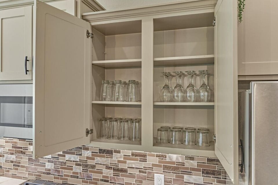 Kitchen glassware cabinet stocked for guest use.