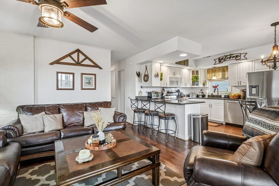 Settle into plush leather seating in your open-concept living space, where rustic charm meets modern comfort. The full kitchen awaits your culinary adventures, complete with stainless appliances and a welcoming island for gathering over meals and memories.
