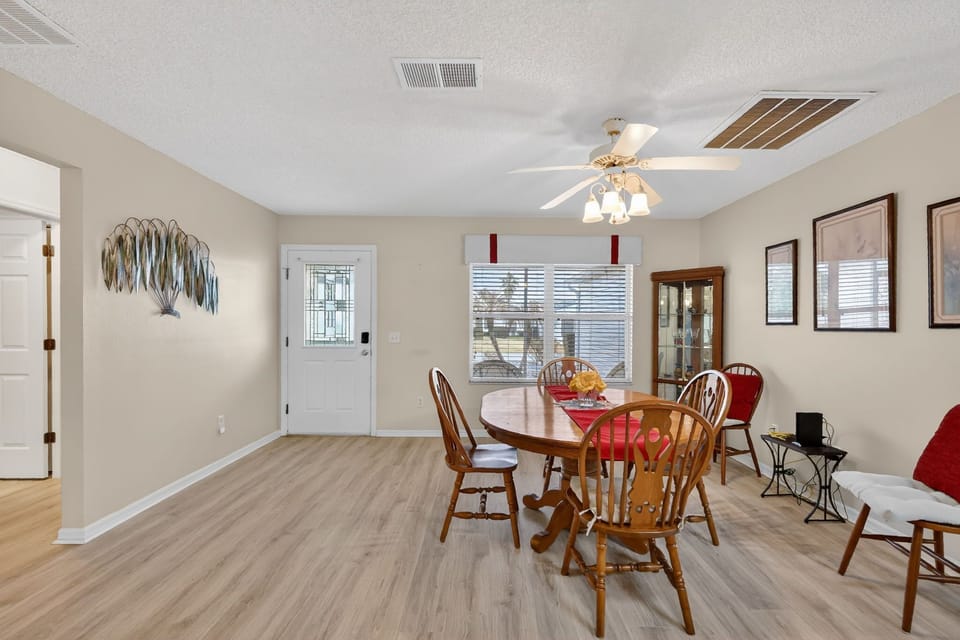Gather around the warm wooden dining table for family meals in this bright, welcoming space with charming decor and natural light.