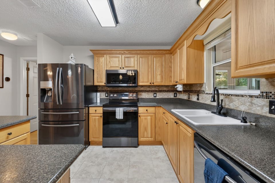 Your fully equipped kitchen features granite countertops, stainless steel appliances, and warm wood cabinetry for all your culinary adventures.