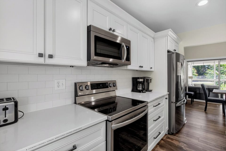 Step into your private kitchen, where stainless-steel appliances meet bright white cabinetry and clean subway tile. Everything you need for a comfortable stay is here, from brewing morning coffee to preparing your favorite meals.