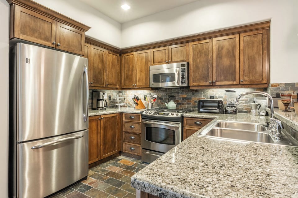 Step into your fully equipped kitchen with granite counters, stainless appliances, and charming wood cabinetry—everything you need to prepare a delicious home-cooked meal.