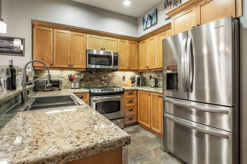 Your fully equipped kitchen features granite countertops, stainless steel appliances, and warm wood cabinetry—everything you need to prepare delicious meals during your stay.
