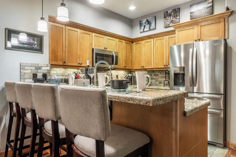 Gather around your fully-equipped kitchen island, perfect for morning coffee or meal prep. Stainless appliances, granite counters, and warm wood cabinetry create a welcoming space to cook and connect.