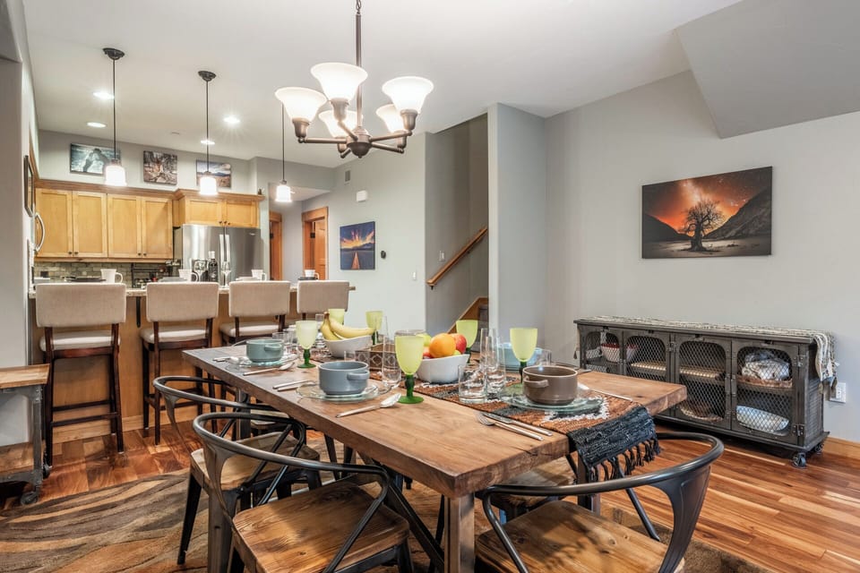 Gather around this inviting dining space where your group can share meals and memories together. The open layout flows seamlessly into a fully-equipped kitchen, perfect for preparing home-cooked favorites during your stay.
