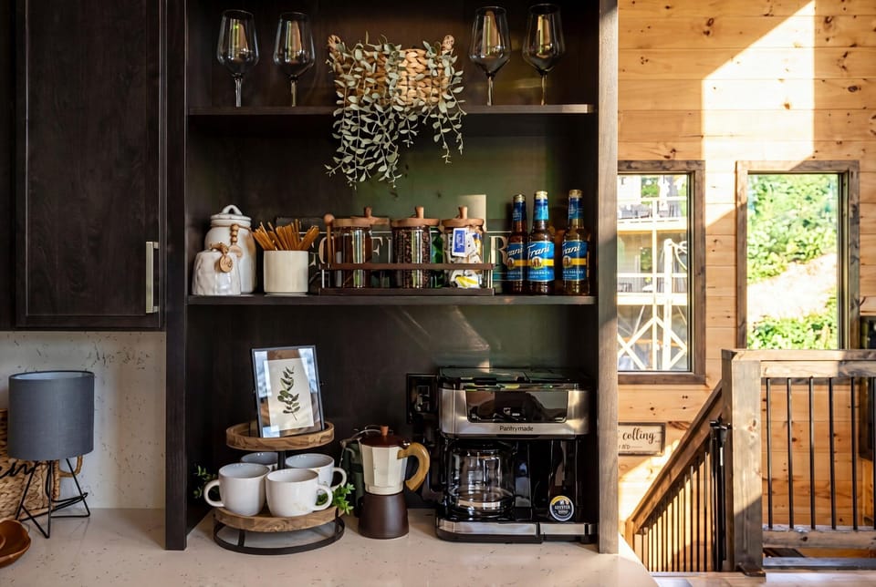 Coffee bar in the upstairs kitchen — beans, syrups, and two ways to brew.
