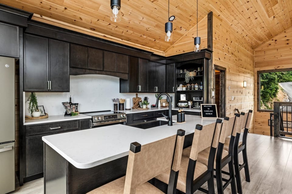The designer kitchen — fully stocked, big island with seating for 4, and a coffee bar in the corner.