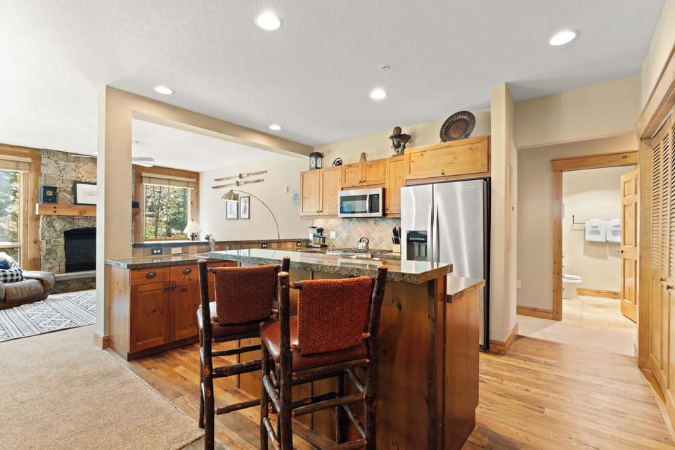 Your inviting kitchen features warm wood cabinetry, granite countertops, modern appliances, and a breakfast bar perfect for casual meals or morning coffee in this bright, welcoming space.