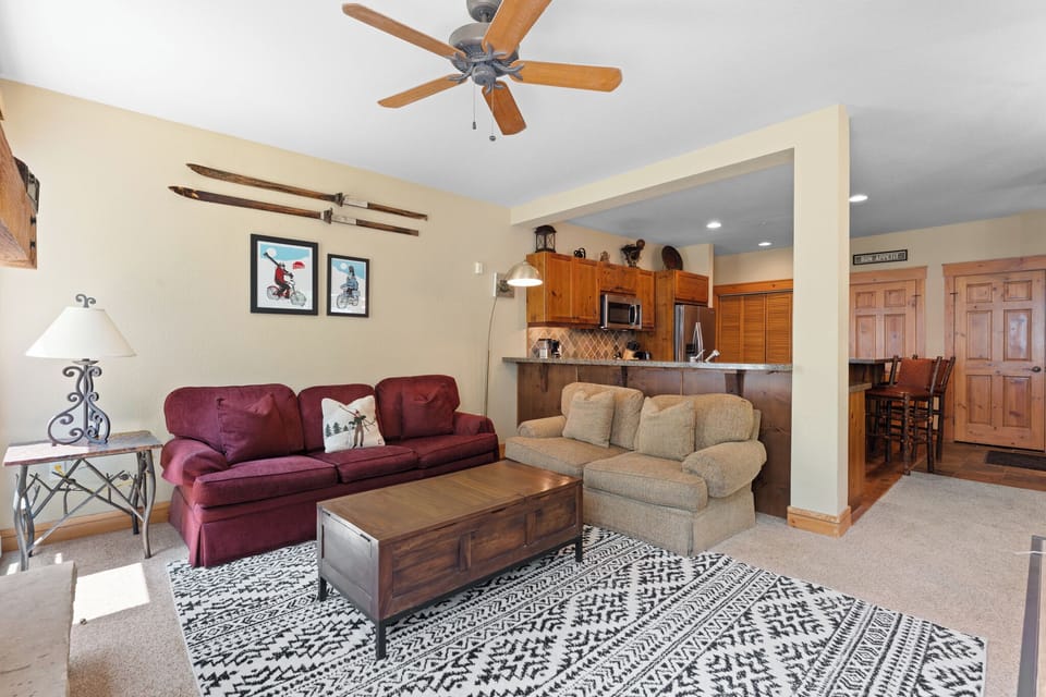 Your open living space welcomes you with cozy seating, mountain breezes from the ceiling fan, and a fully equipped kitchen—perfect for relaxing after a day of adventure.