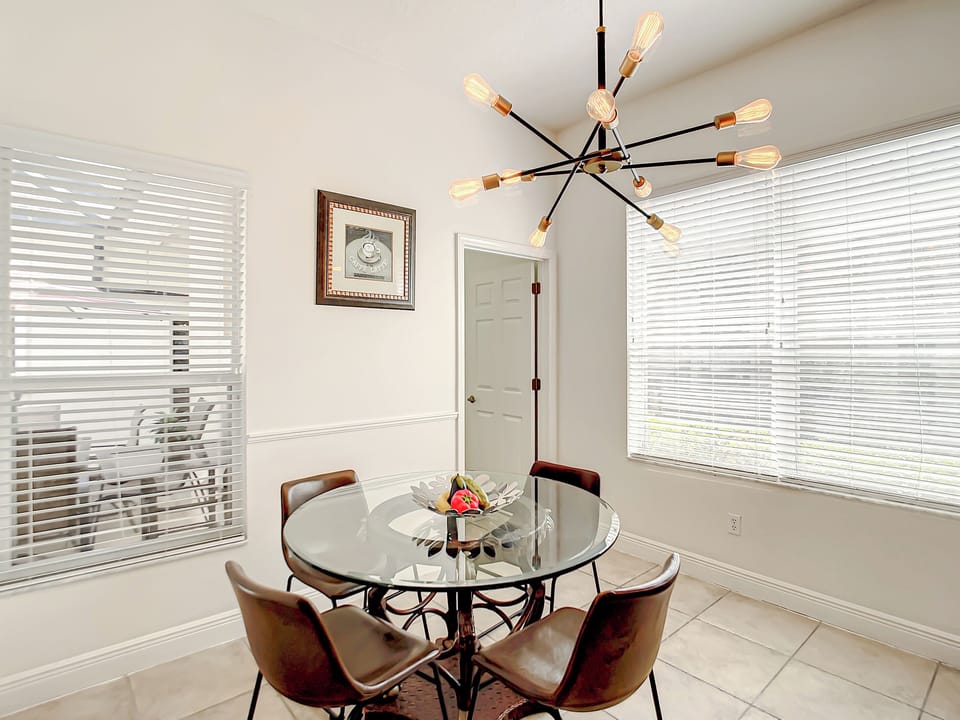 Dining Area: Gather around the chic glass table and enjoy the views through sunny windows!