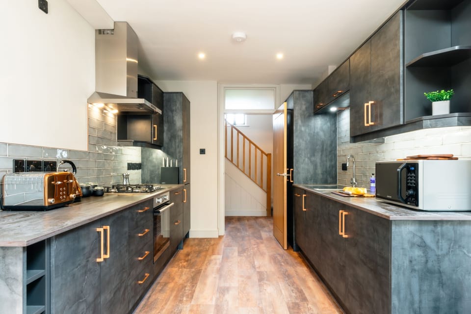View of the high-spec kitchen from the living area, with entrance hall behind