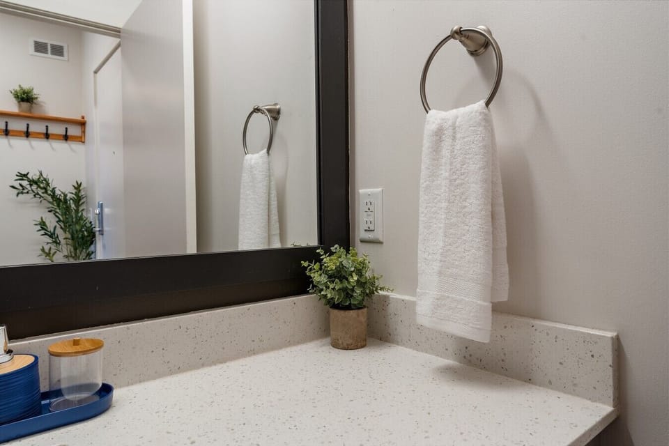 Modern bathroom vanity with fresh hand towels, bright lighting, and thoughtful details for a comfortable stay.
