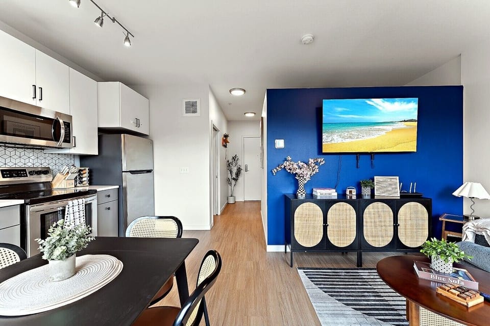 Comfortable living area with smart TV, stylish accent wall, and easy access to the kitchen.