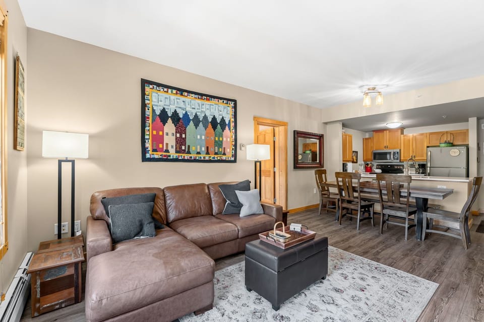 Sink into the plush leather sectional in your open-concept living space, where modern comfort meets mountain charm. The full kitchen and inviting dining area make gatherings effortless.