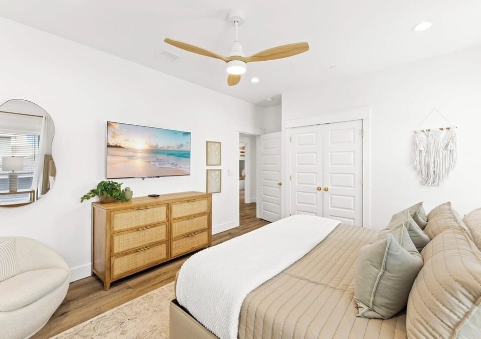 2nd Floor - King Suite featuring a plush king bed, private ensuite bathroom with a walk-in glass shower, and a 4K Smart TV. A comfortable and private retreat designed for rest and relaxation after a day at the beach.