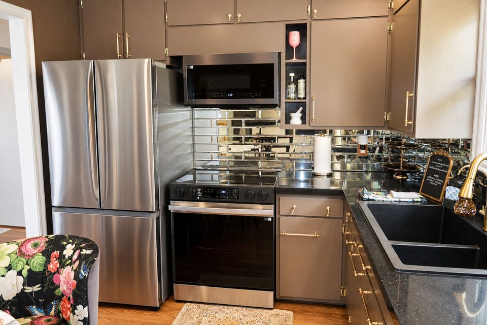 Stylish kitchen with stainless appliances and luxe mirrored backsplash