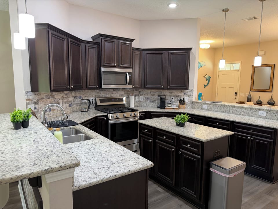 Spacious gourmet kitchen with granite counters and stylish dark cabinetry