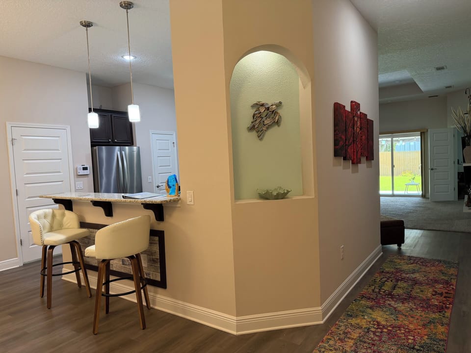 Bright open entry with breakfast bar, pendant lights, and stylish finishes