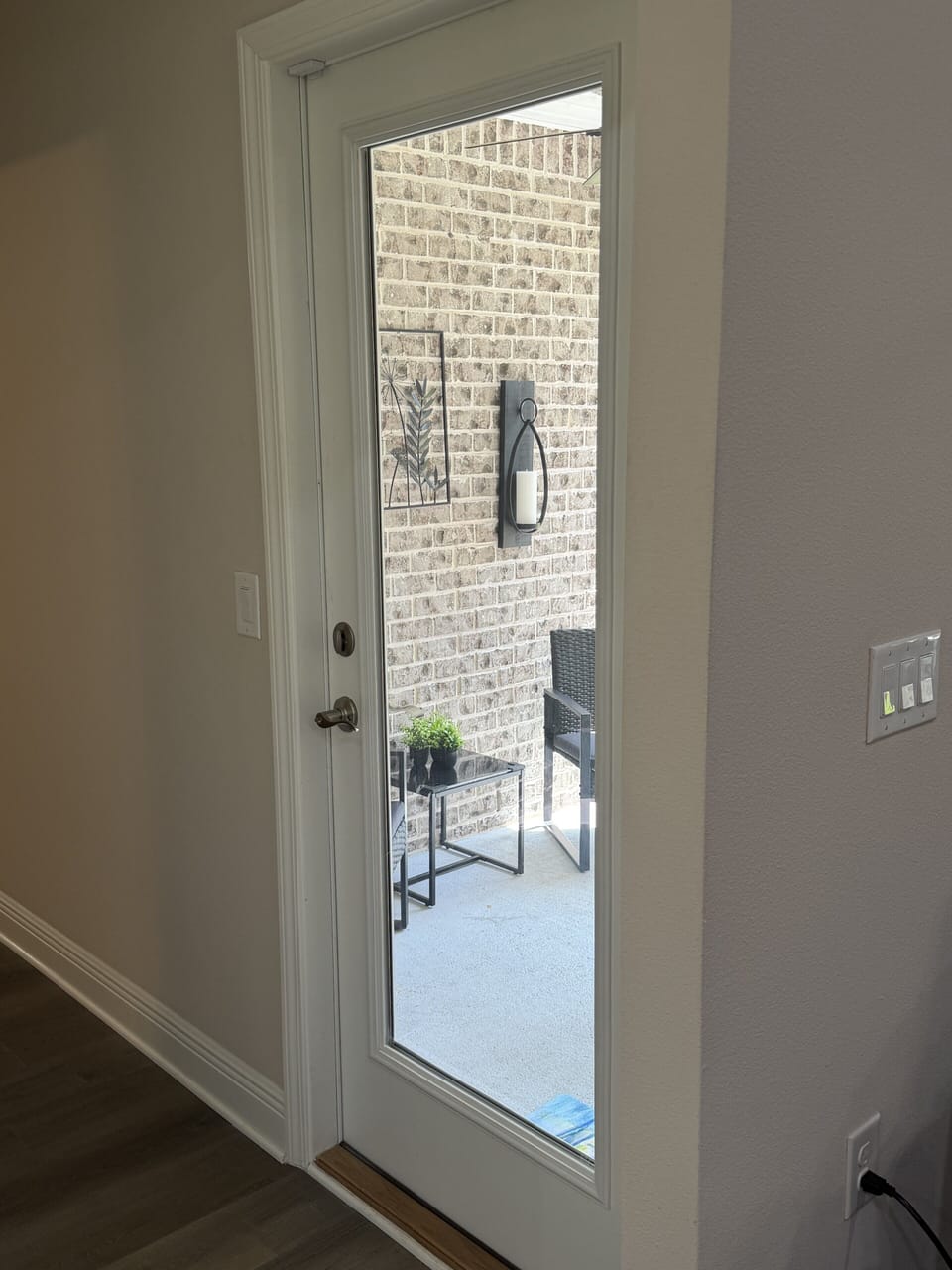 Glass back door opens to a charming brick patio with modern seating