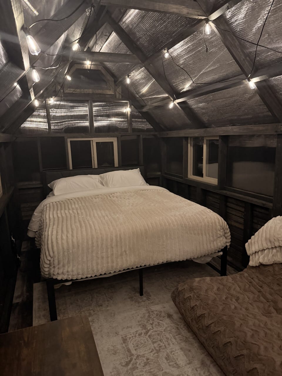 Cozy loft bedroom with warm lighting and unique cabin-style charm