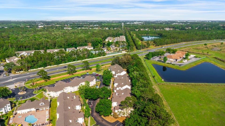 Aerial view of a residential community surrounded by greenery and water features.