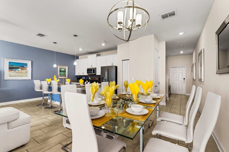 Elegant dining setup with a glass table, yellow napkins, and modern chairs, perfect for family meals or entertaining guests. Bright and welcoming atmosphere.