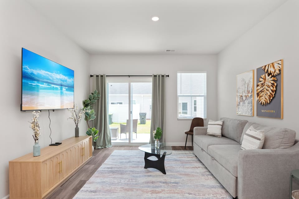 Bright living room featuring a large wall-mounted TV and modern decor.
