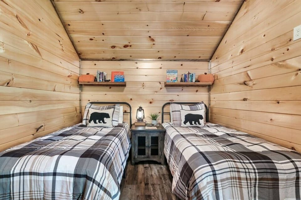 Perfect for kids or friends, this inviting bedroom features two comfortable twin beds, charming cabin décor, and a selection of books for quiet evenings.