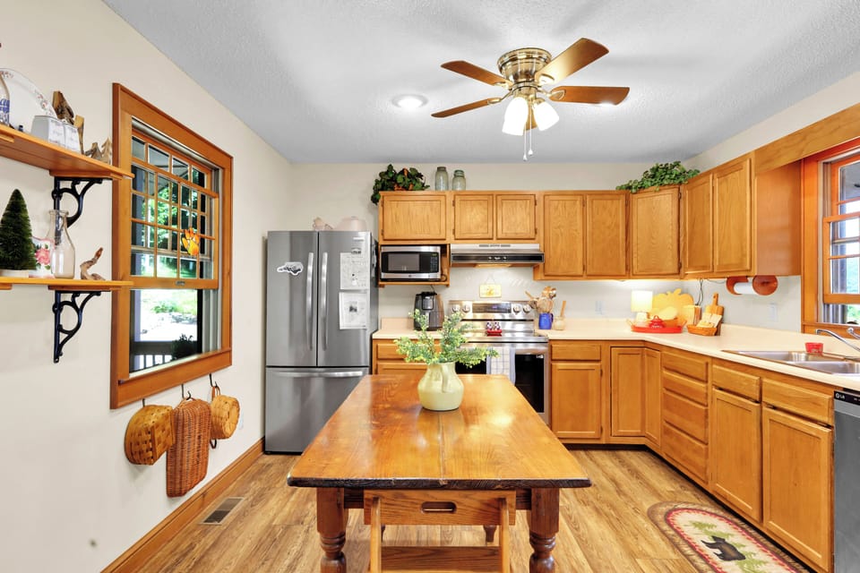 Bright farmhouse-style kitchen with island, stainless appliances, and warm wood charm