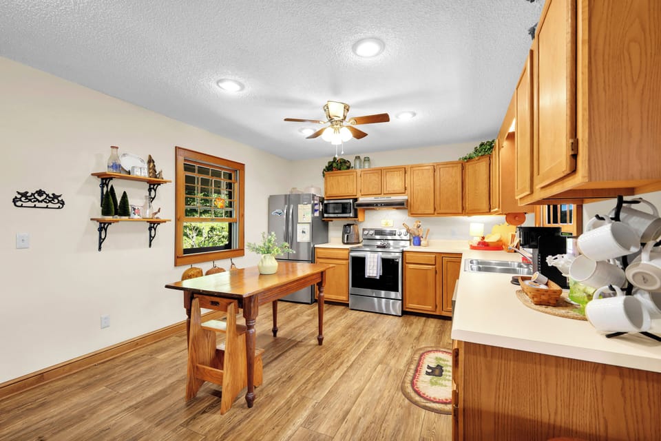 Whip up a feast in this bright full kitchen, featuring a cozy dining nook, stainless appliances, and warm wood finishes — a stylish, functional space for mountain meals together.