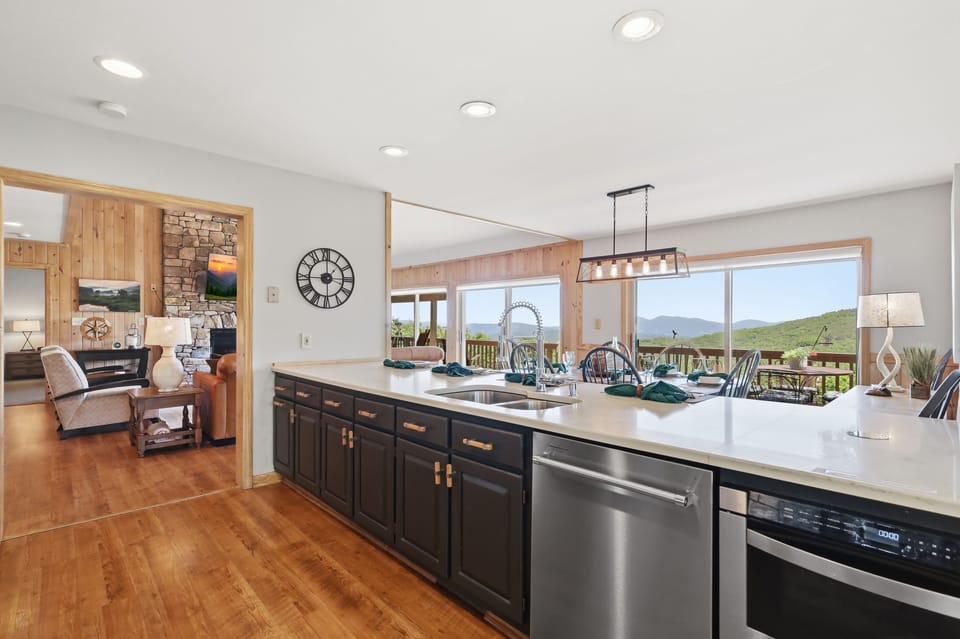 The bright mountain-view kitchen is as functional as it is stunning — a large center island, open-concept layout, and gorgeous views make cooking and gathering here an absolute highlight of the stay.